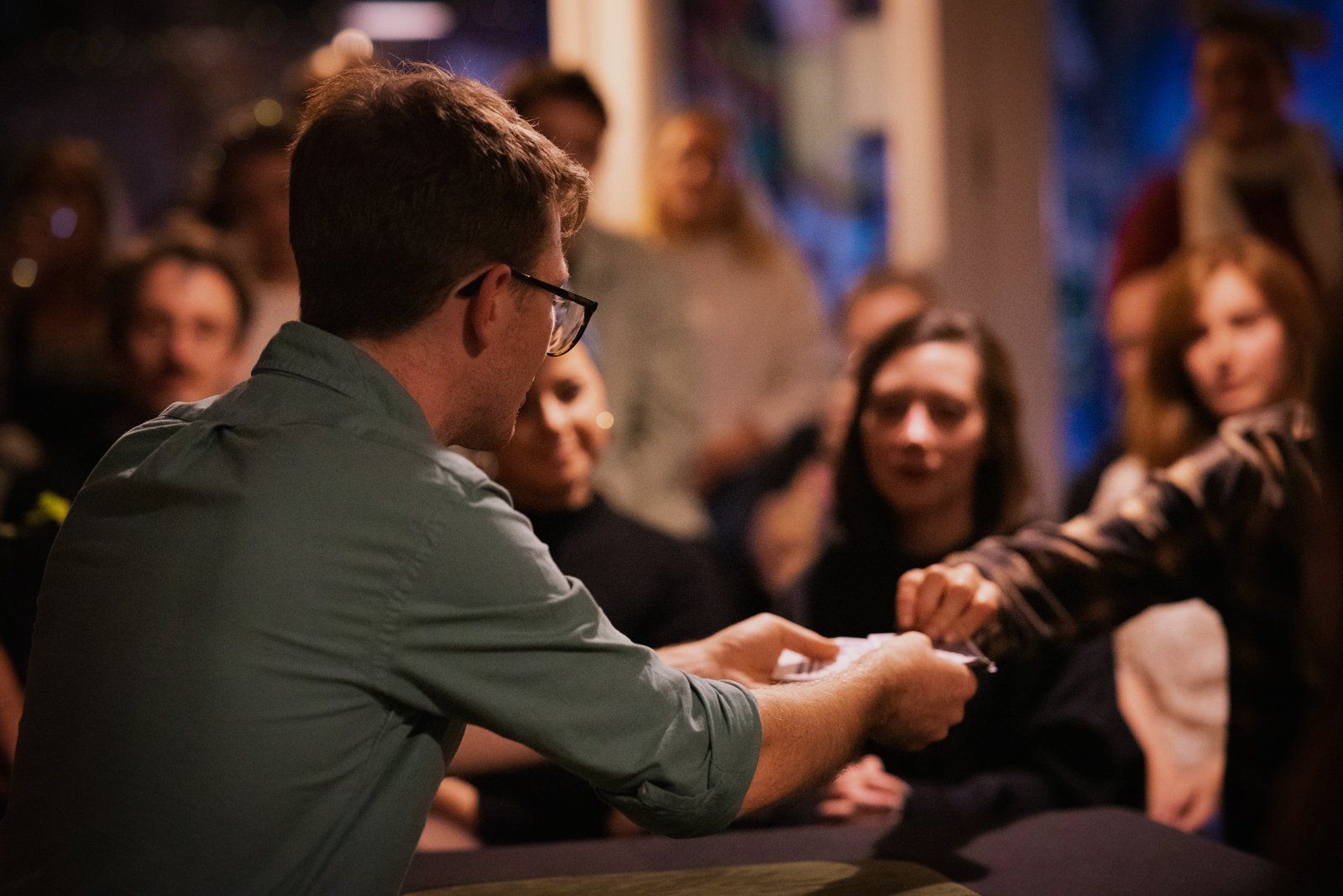 Sam King performing close-up magic to a captivated crowd
